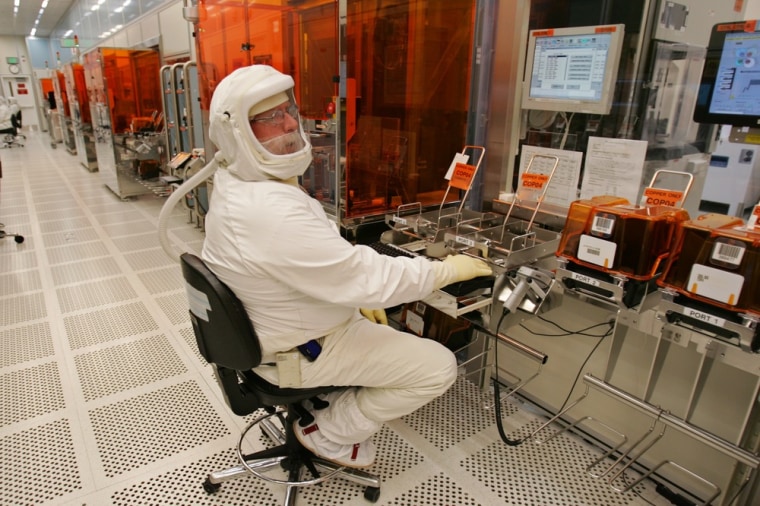 A manufacturing technician produces chips in a clean room at Intel headquarters in Santa Clara, Calif. Robots, however, are typically better at this type of work than humans